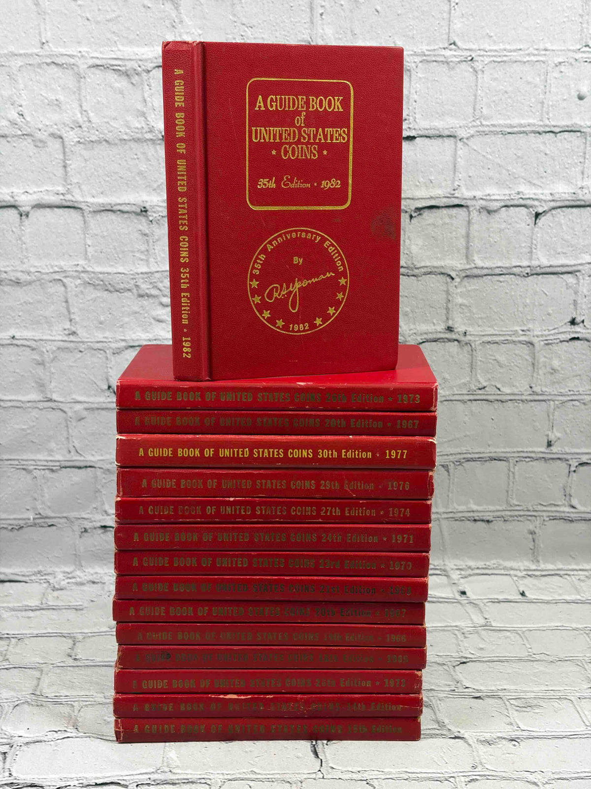 A Guide Book of United States Coins (Red Book) lot of 15 by R. S. Yeoman, 1961-1982 - stack with the 1982 35th edition on top
